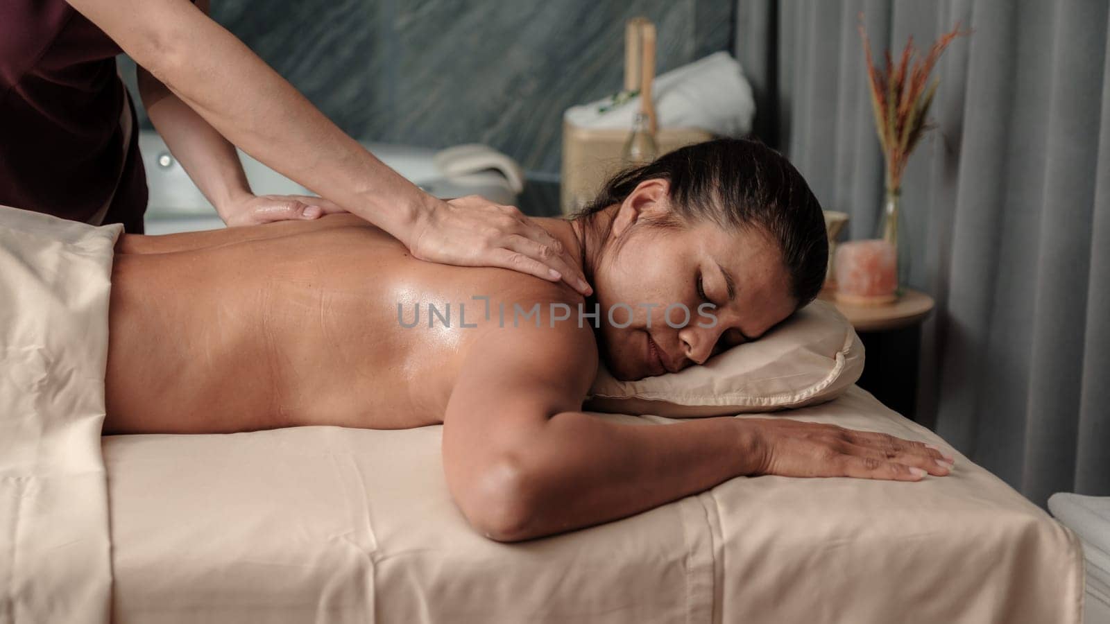 Asian woman getting a Thai massage in a Massage room in Thailand at a luxury hotel spa, close up of woman hands giving a massage