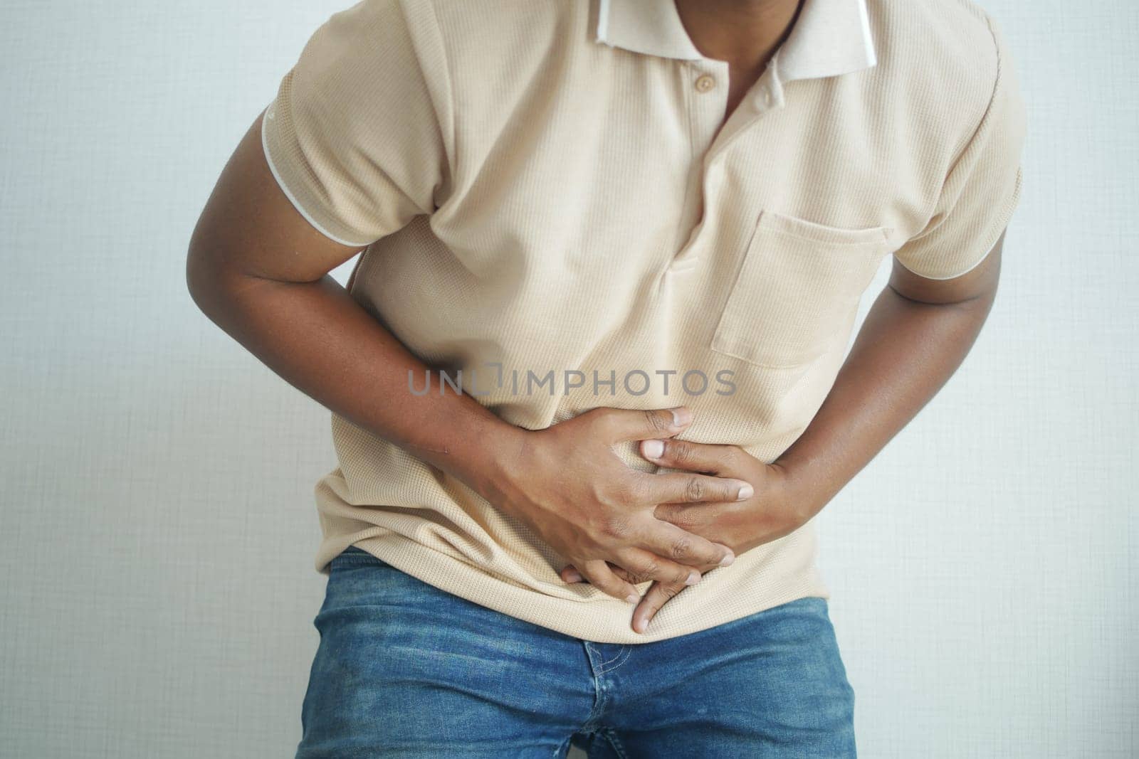 young man suffering stomach pain close up