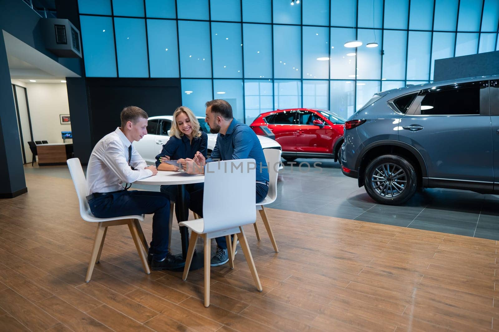 Happy caucasian couple signs a contract for the purchase of a car salon. by mrwed54