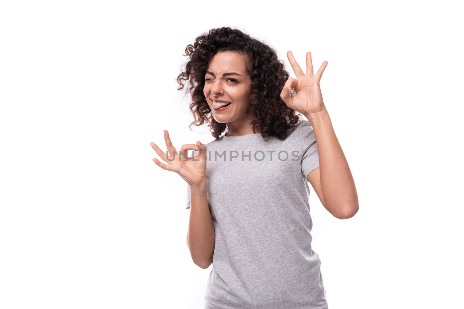 young charming curly woman dressed in a gray basic t-shirt for branding print.