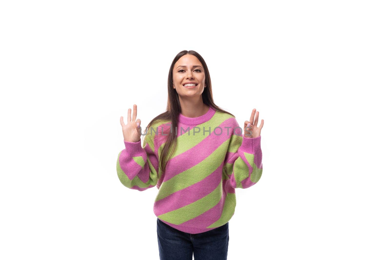 portrait of a well-groomed 35 year old feminine model woman dressed in a pink stylish pullover on a white background with copy space.