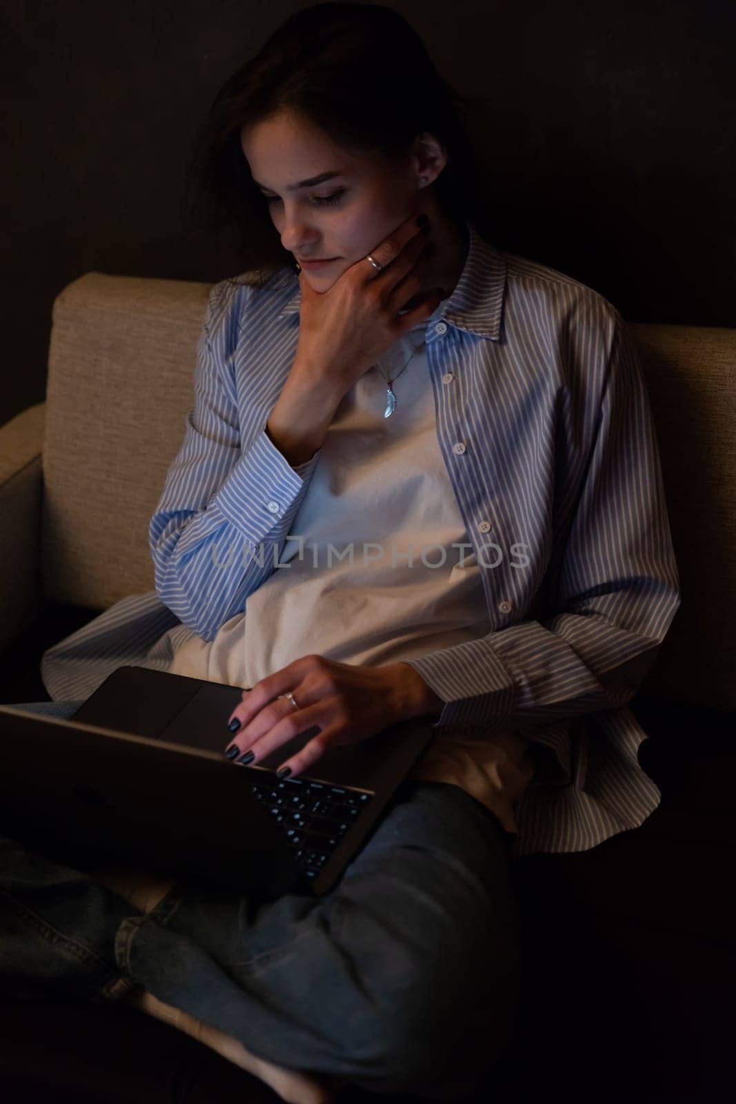 Woman sitting on sofa with computer chatting online job by Simakov