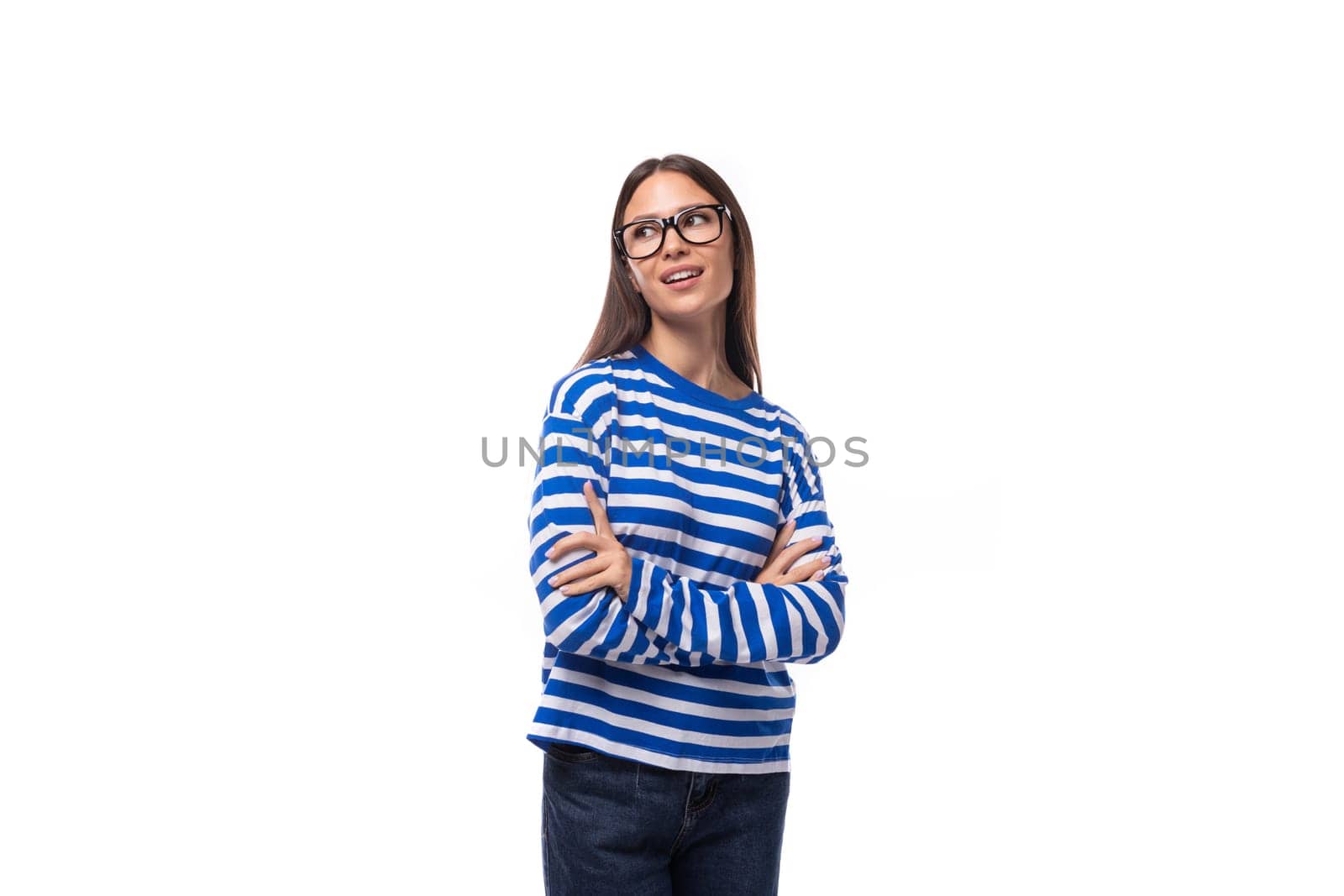 portrait of a European pretty brunette young lady in a casual striped sweater and jeans on a white background. people lifestyle concept.