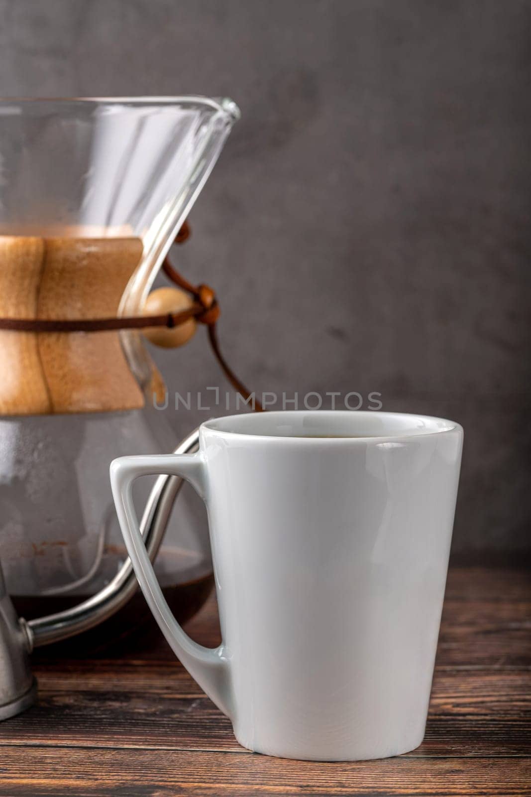 A cup of coffee and third generation pour over coffee brewing equipment on stone floor by Sonat