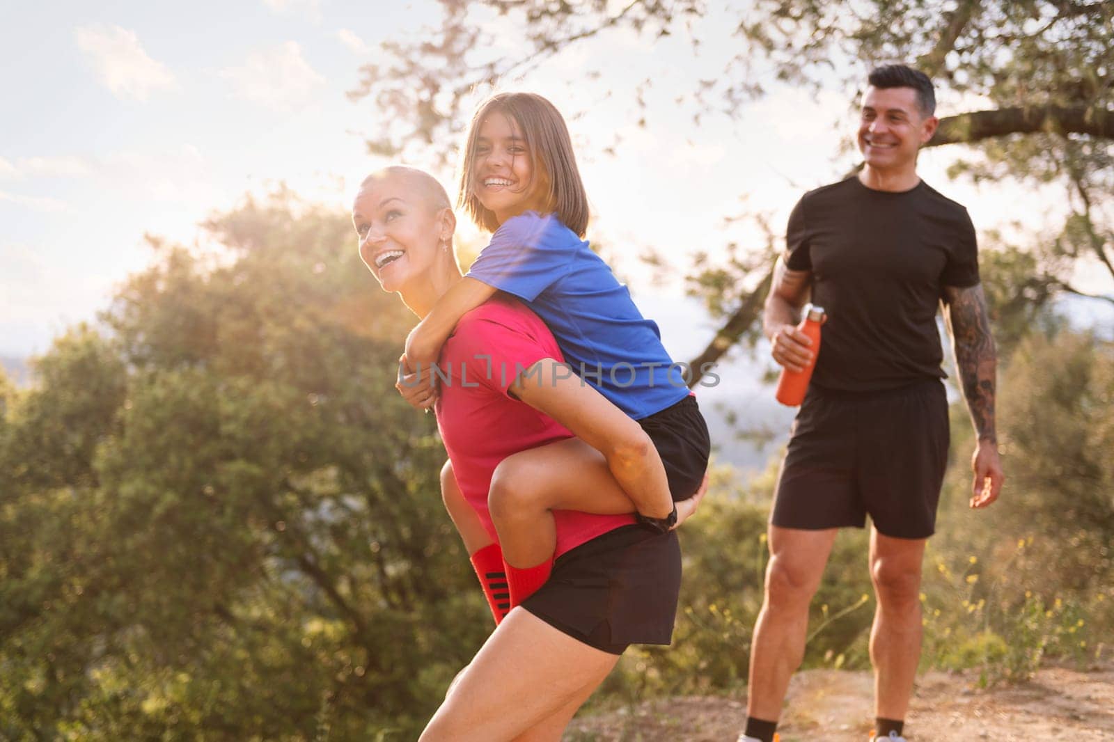 sporty family playing happy and joking during their training in the countryside, concept of sport with kids in nature and active lifestyle, copy space for text