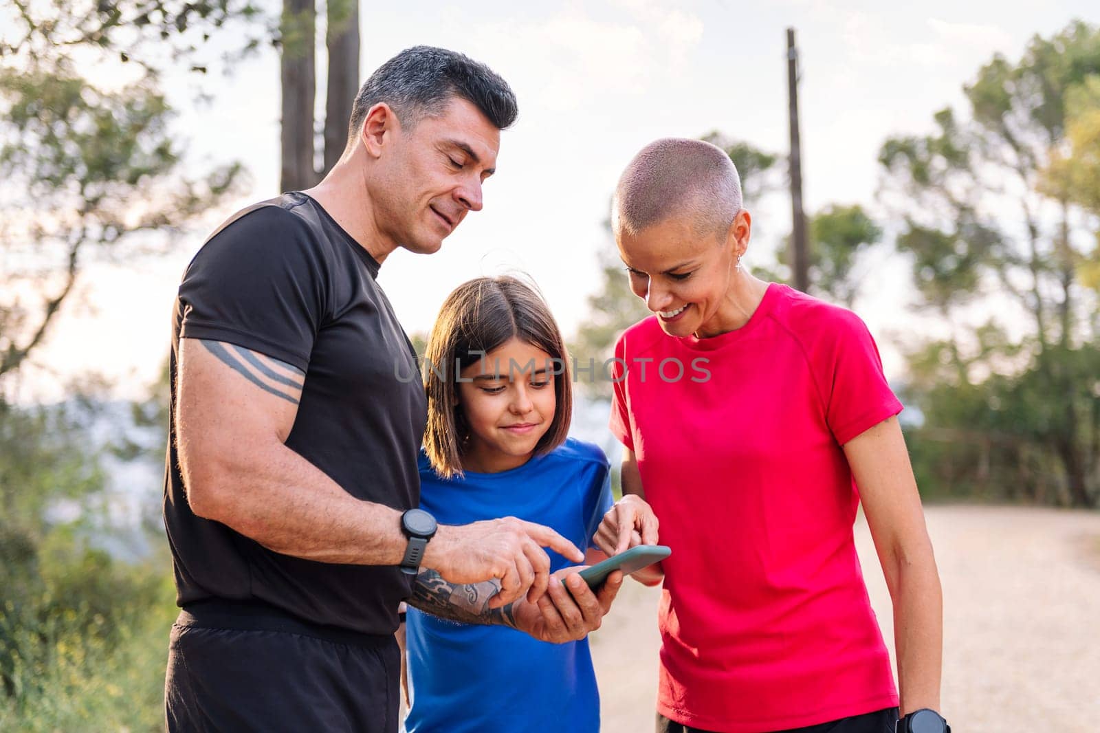 sporty family using phone to plan their training by raulmelldo