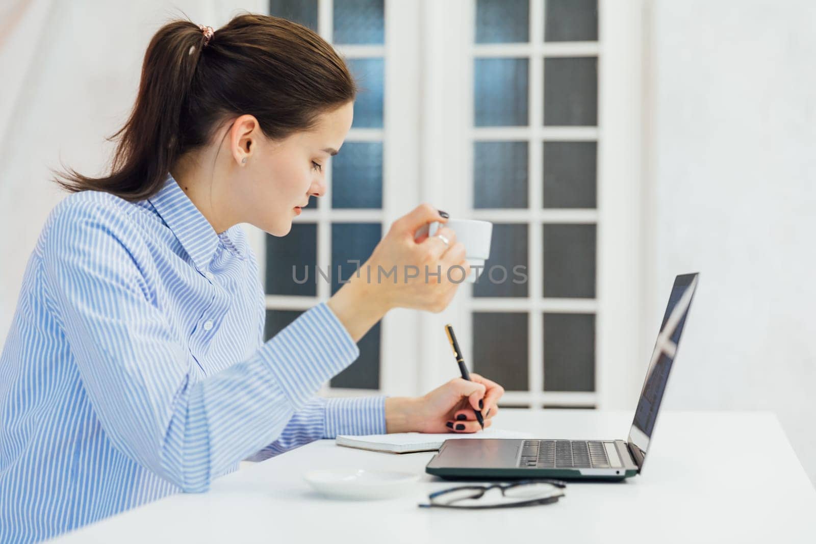 woman secretary in office working online on computer