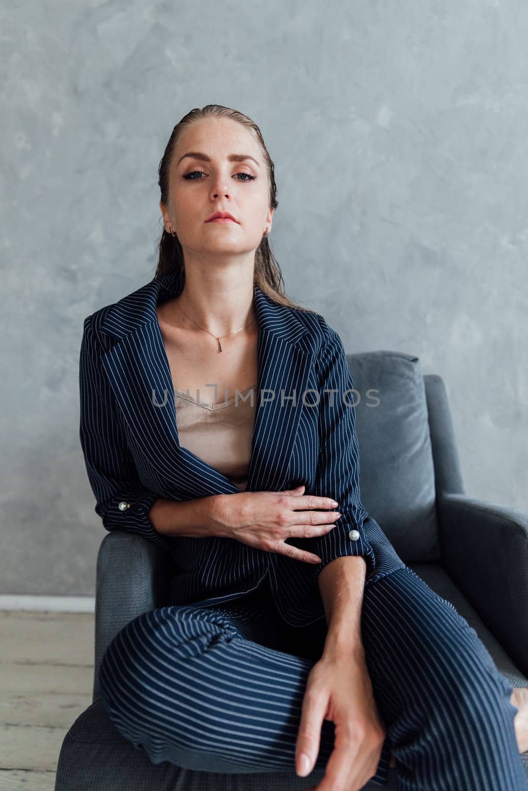 woman in a business suit sits in a chair in an office space in a room