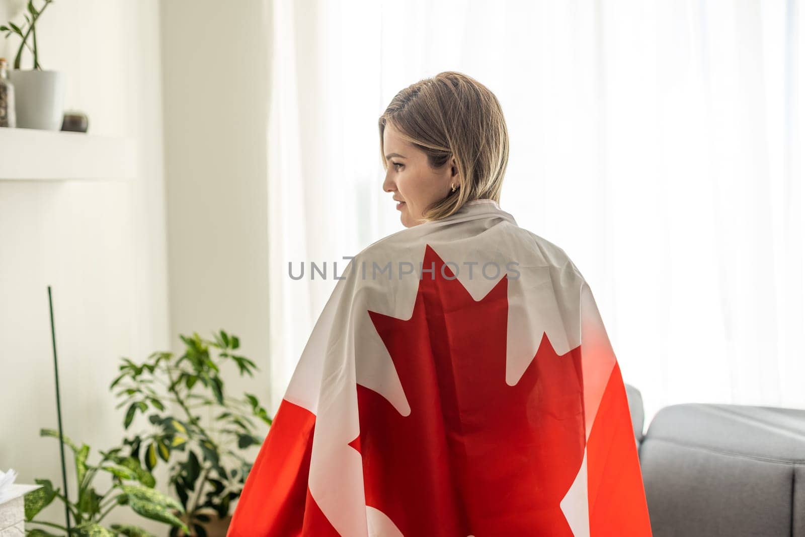 Happy young woman with the flag of Canada on a light white background. Portraits Canadian student female. High quality photo
