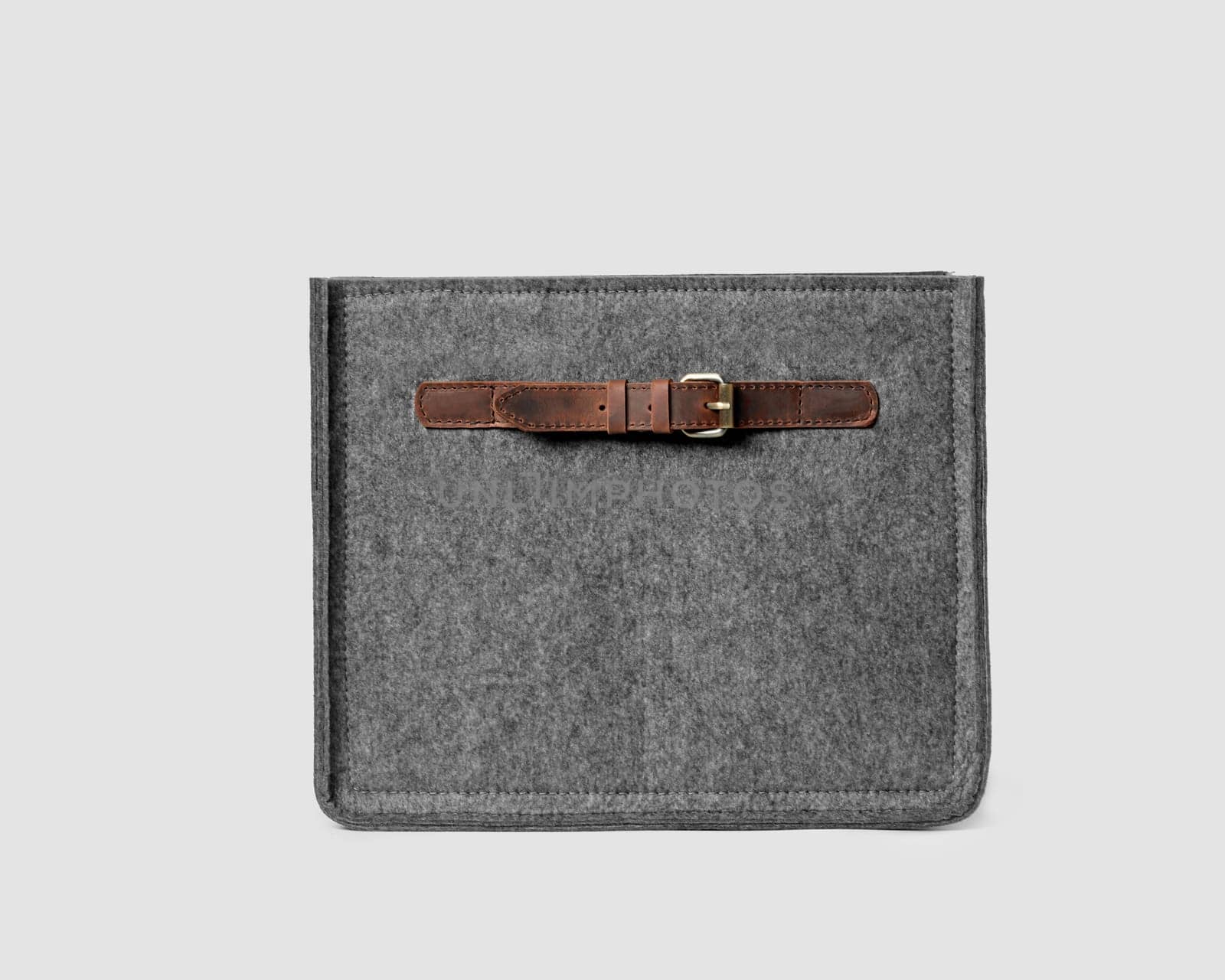 Gray storage box made of natural felt with leather handles and buckles. Stylish artisanal accessory to organize wardrobe or workplace