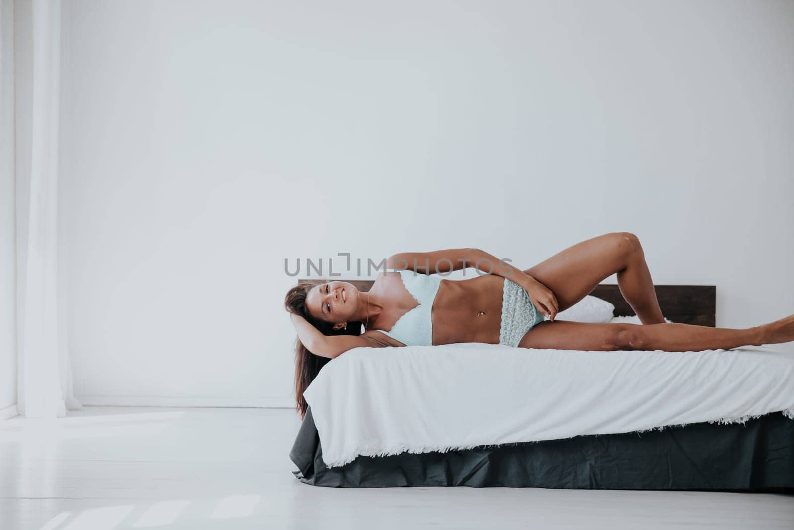 woman in underwear lies on the bed in the bedroom in the morning