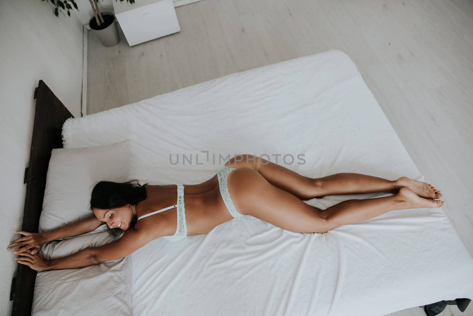 woman in underwear lies on the bed in the morning in the bedroom and stretches