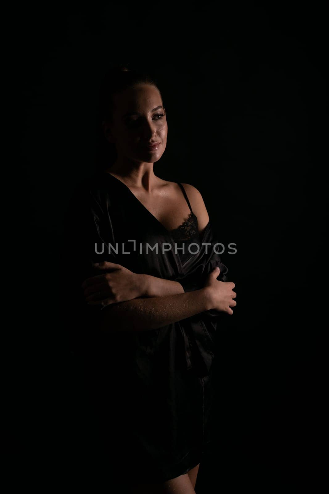a woman in a black nightgown stands in the background in the shade