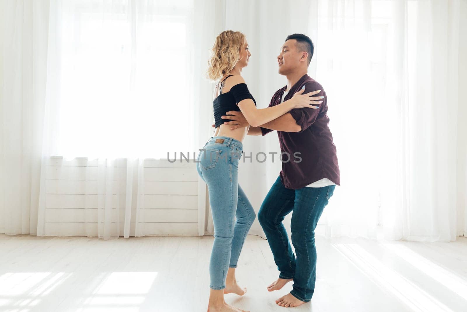 a man and a woman dance in the large bright hall of the school studio
