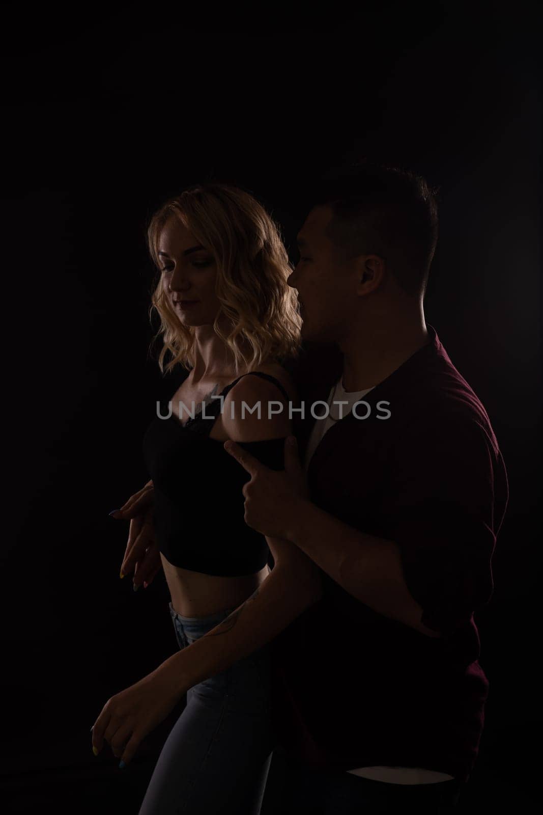 man and a woman in love dance in a dark hall