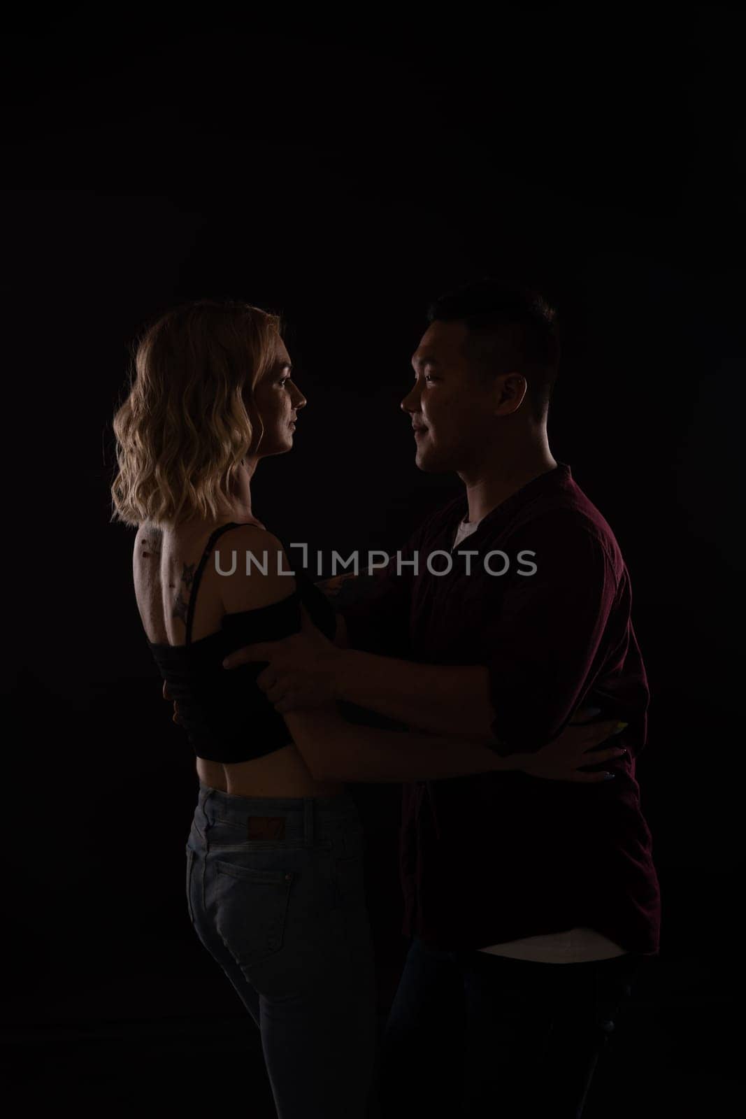 a man and a woman in love dance in dark hall