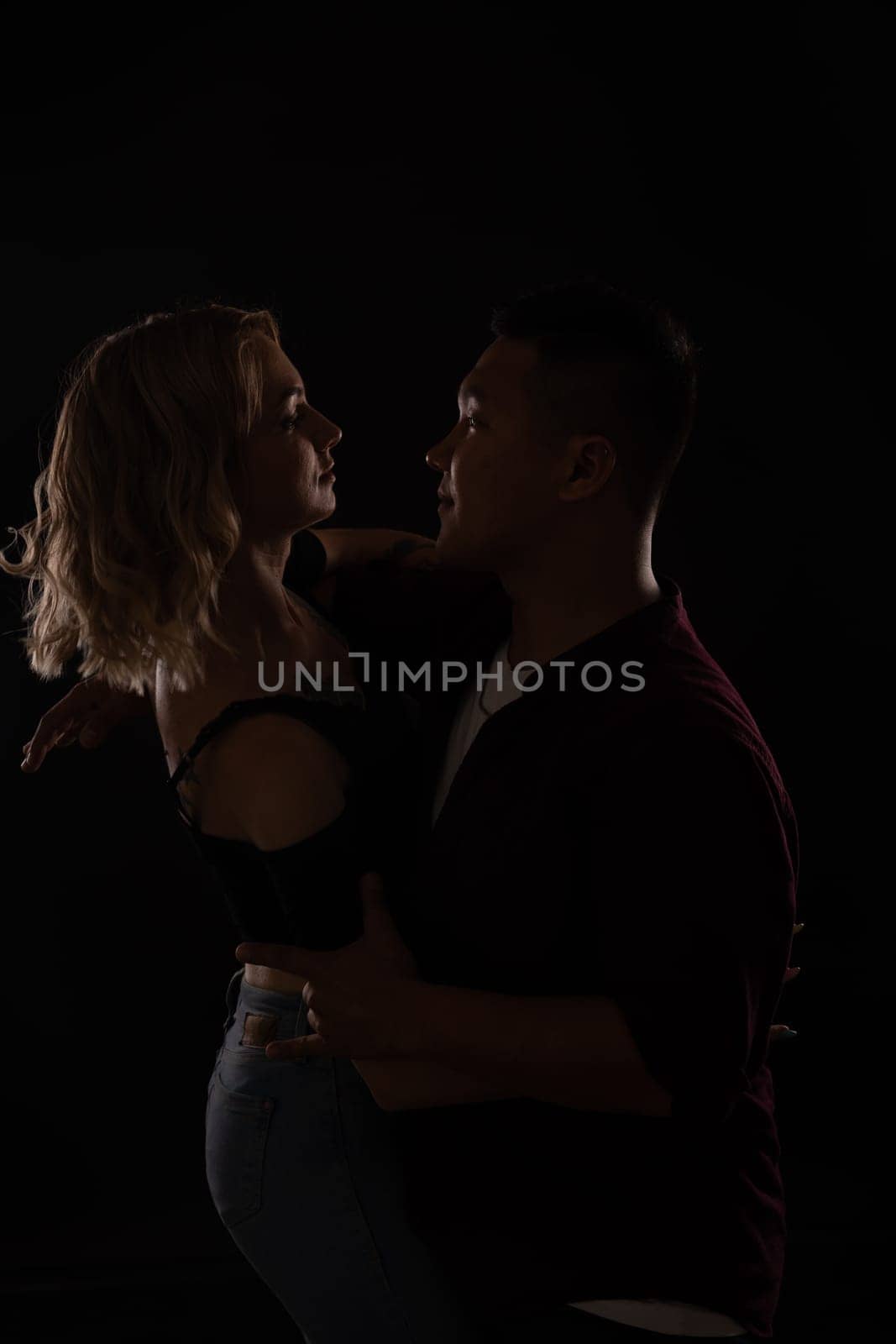 a man and a woman in love dance in dark hall