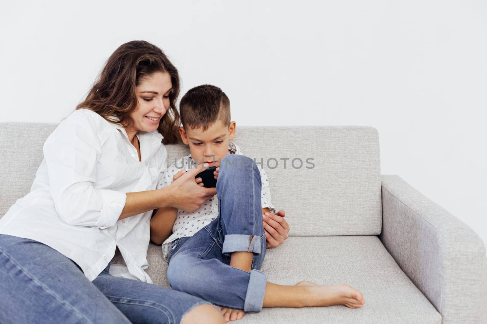 baby and mom plays in phone uses internet on smartphone by Simakov
