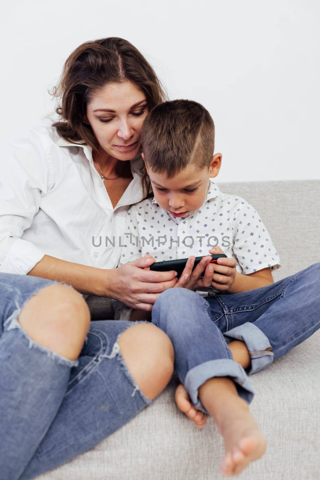 baby and mom plays in phone uses internet on smartphone by Simakov