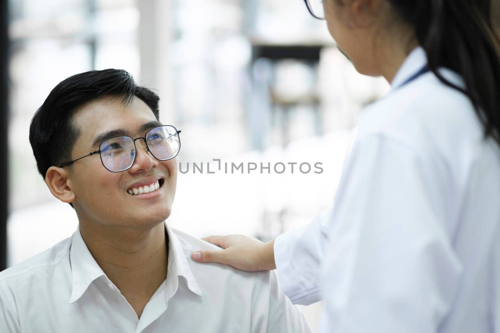 A happy young is smiling while his doctor is support him by ijeab