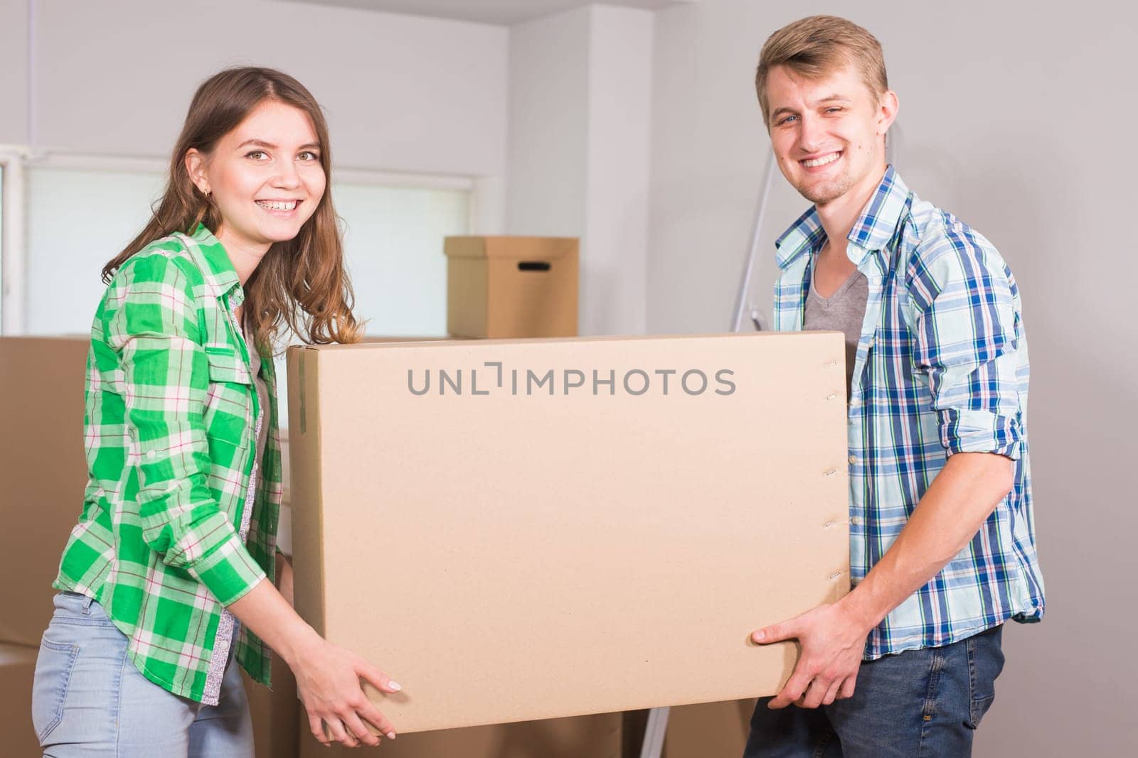 Happy young couple unpacking or packing boxes and moving into a new home