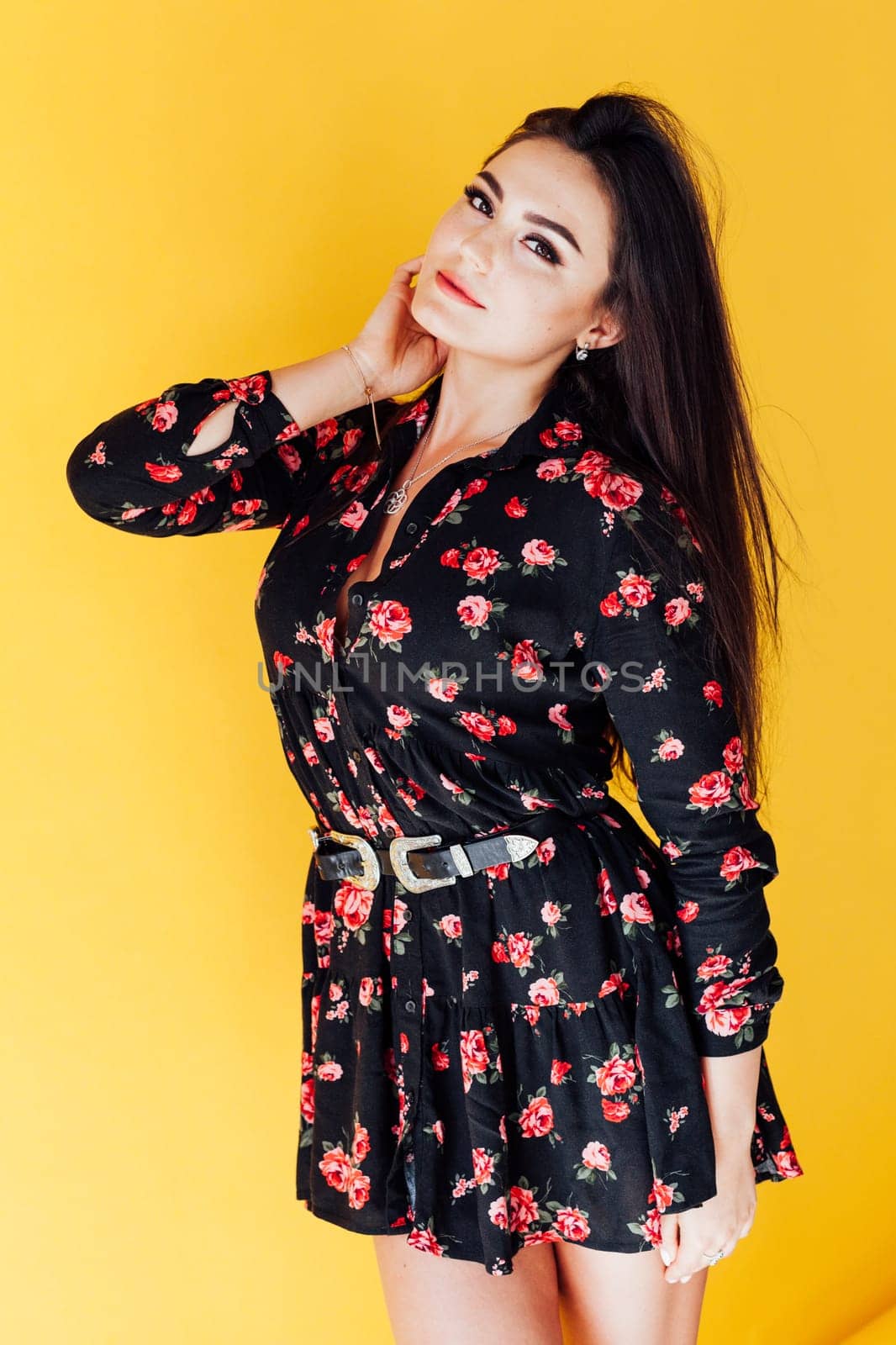 fashionable brunette woman posing on yellow background