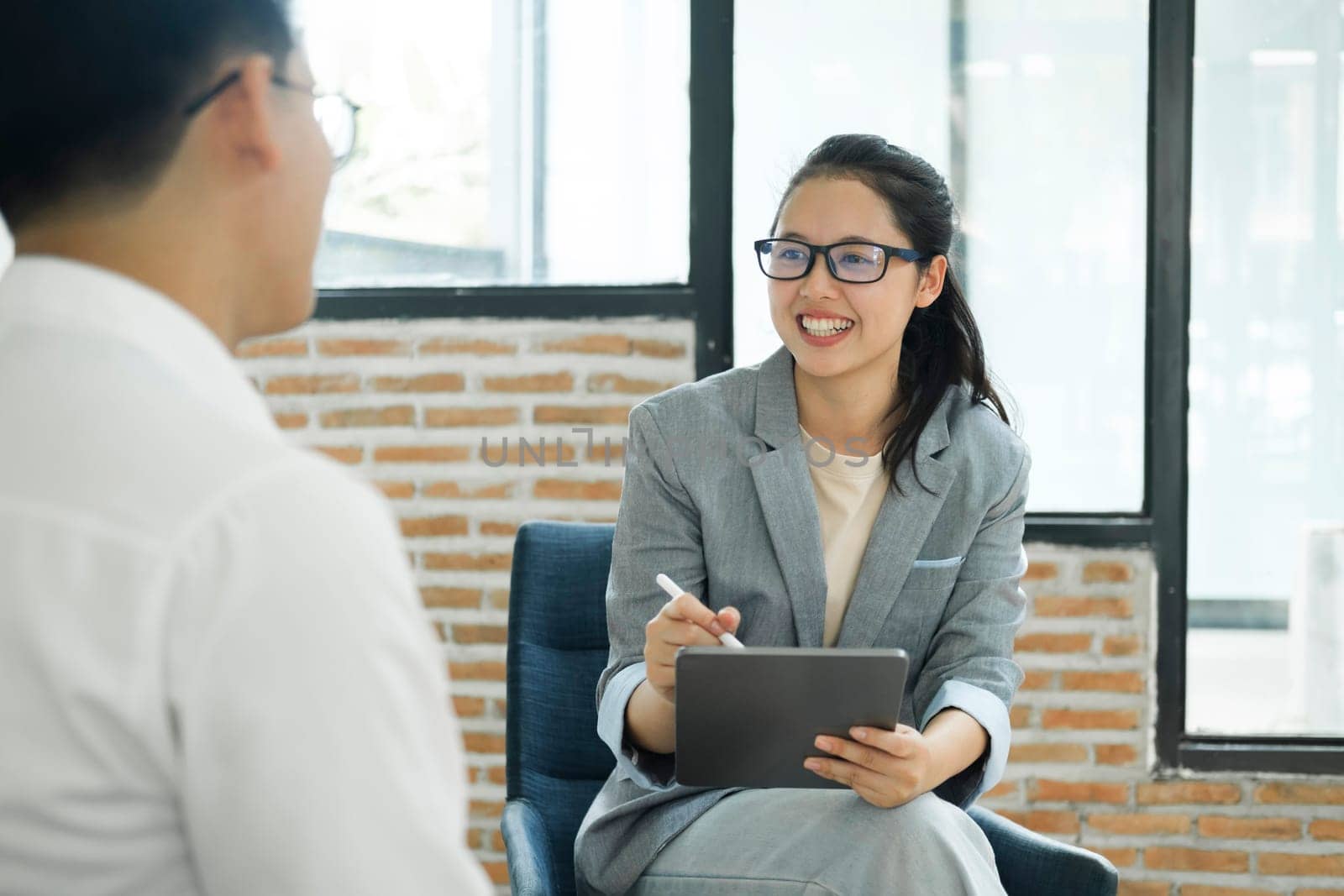 Happy hiring manager interviewing a job candidate in her office by ijeab