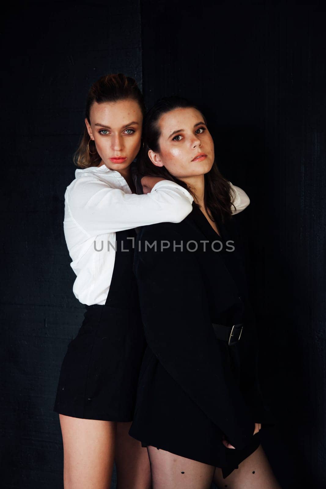 two female friends black white dark background black clothe