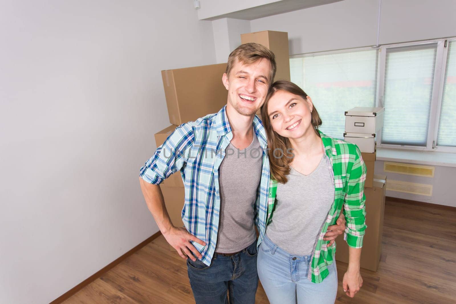 Happy funny couple moving in a new house. by Satura86