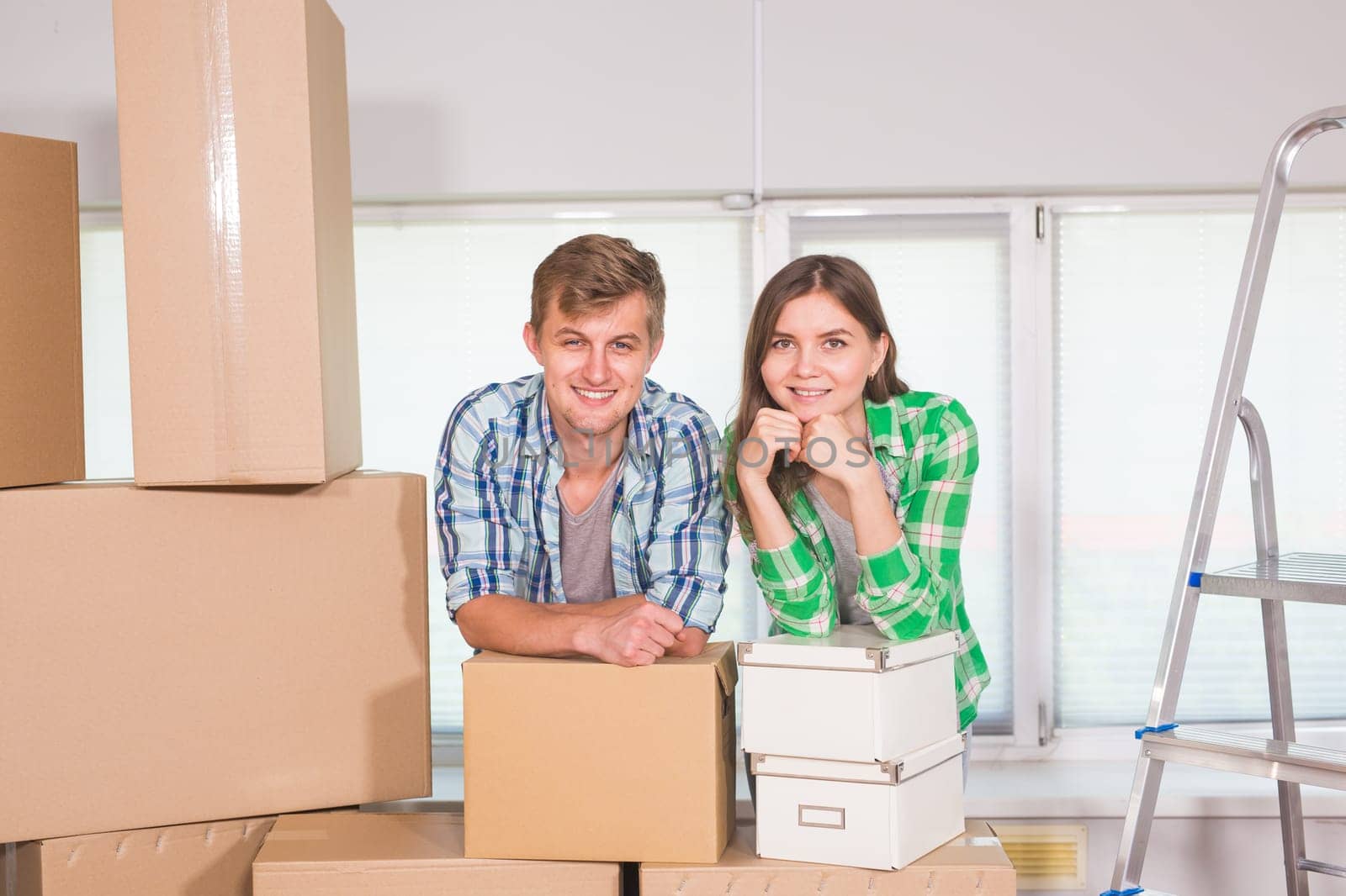 home, people, moving and real estate concept - happy couple with cardboard boxes at new home by Satura86
