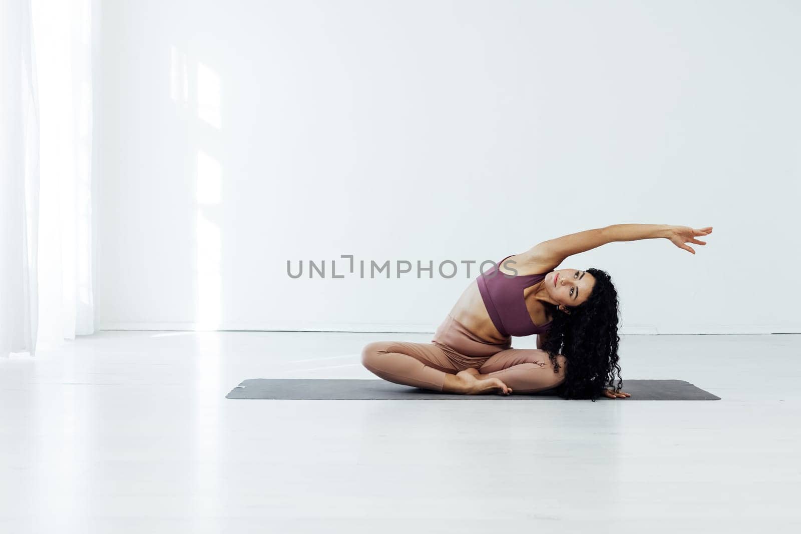 female gymnast doing yoga exercises for weight loss in the gym by Simakov