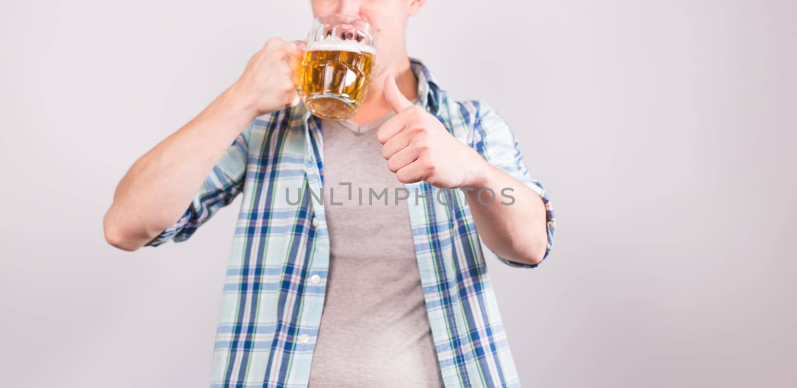 Close up of man holding a mug of beer and showing thumbs up by Satura86