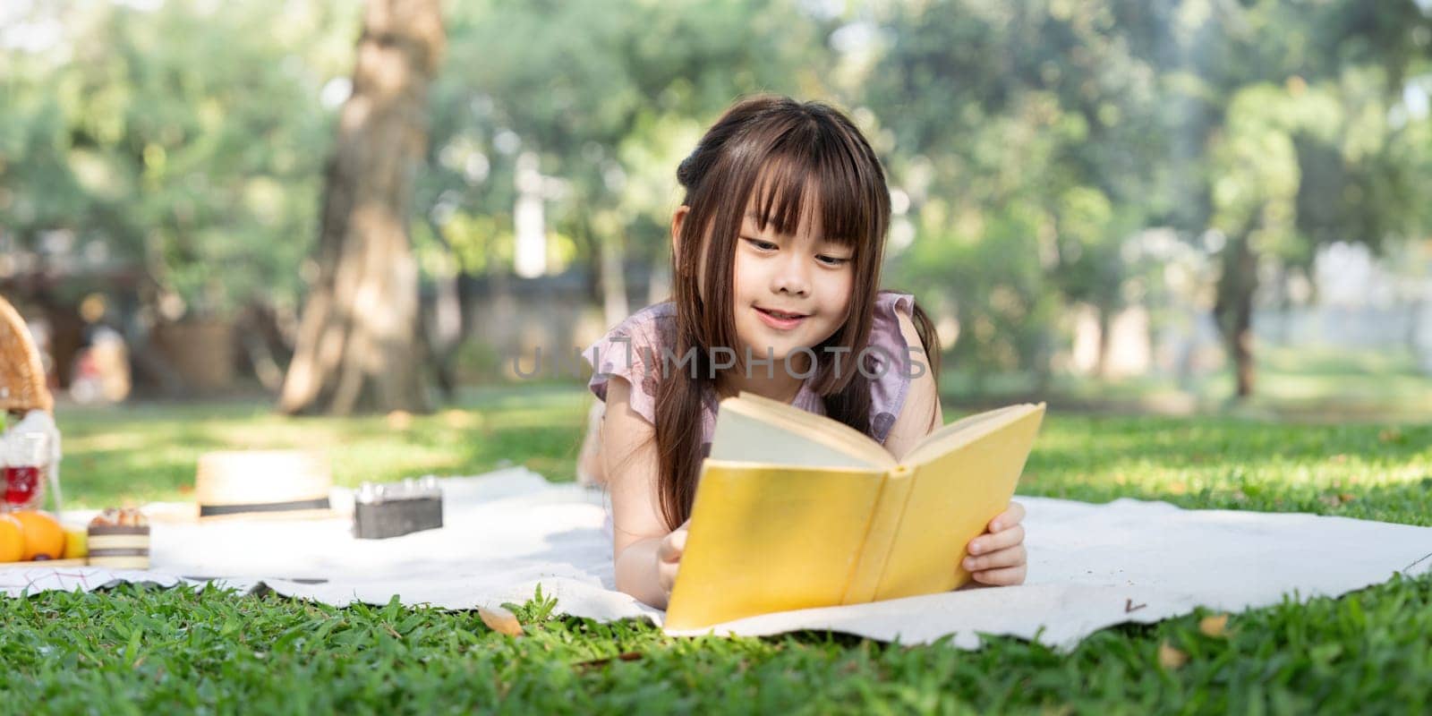 Cute little girl asian read book in park by nateemee