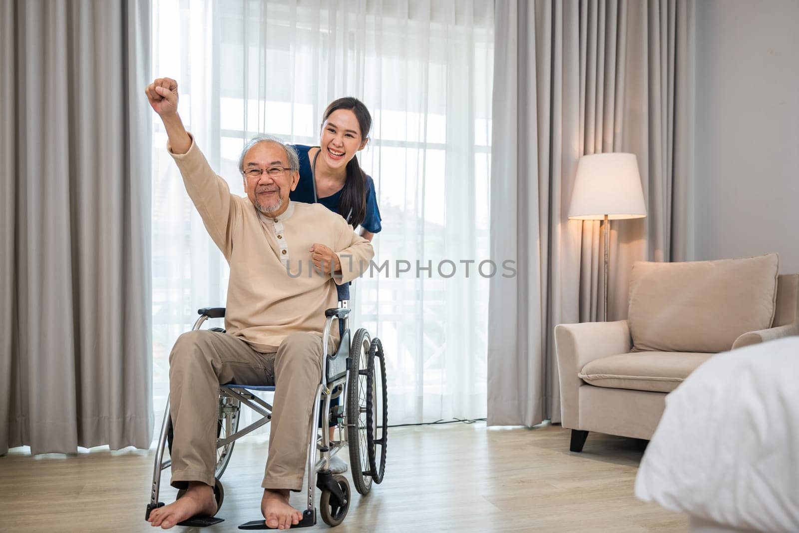 doctor pushing wheelchair and run elderly disabled patient freedom raising arm at hospital by Sorapop