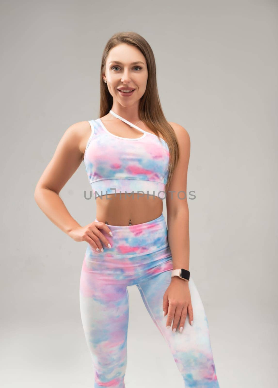 sexy athletic girl in a tight fitness tracksuit on a light background copy paste in the studio by Rotozey