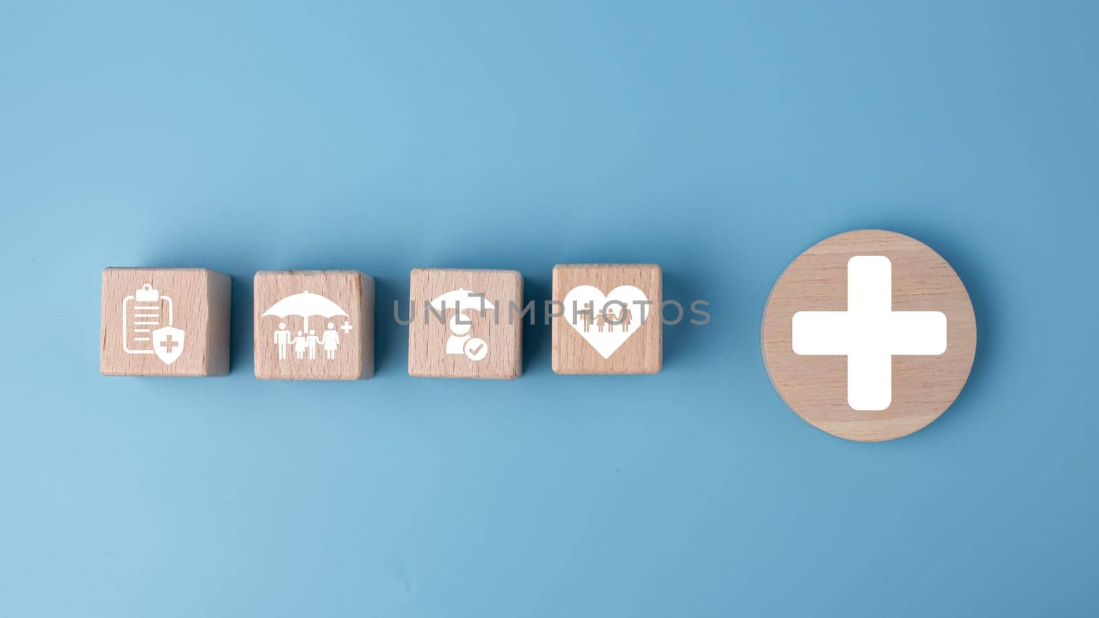 Concept of health insurance and medical. Wooden block with icons about health insurance and access to health care, health care planning on a blue background. by Unimages2527