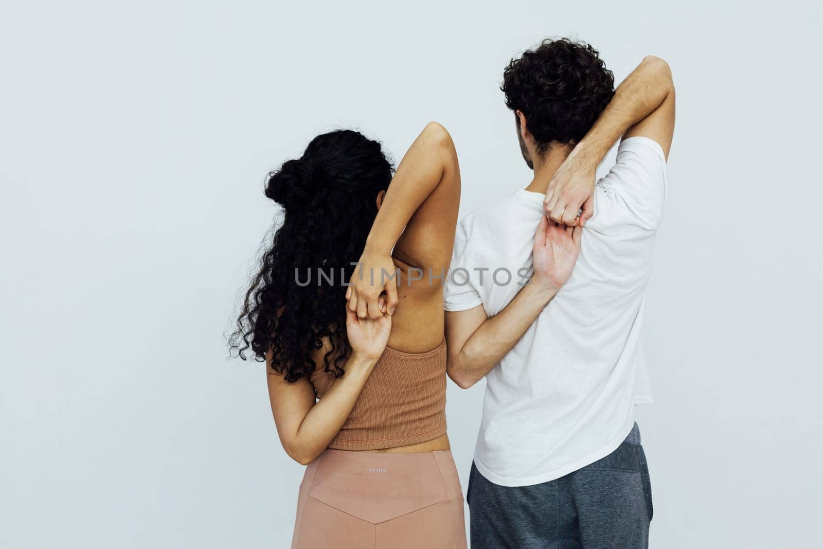 a woman and a man stand with their backs folded into a lock