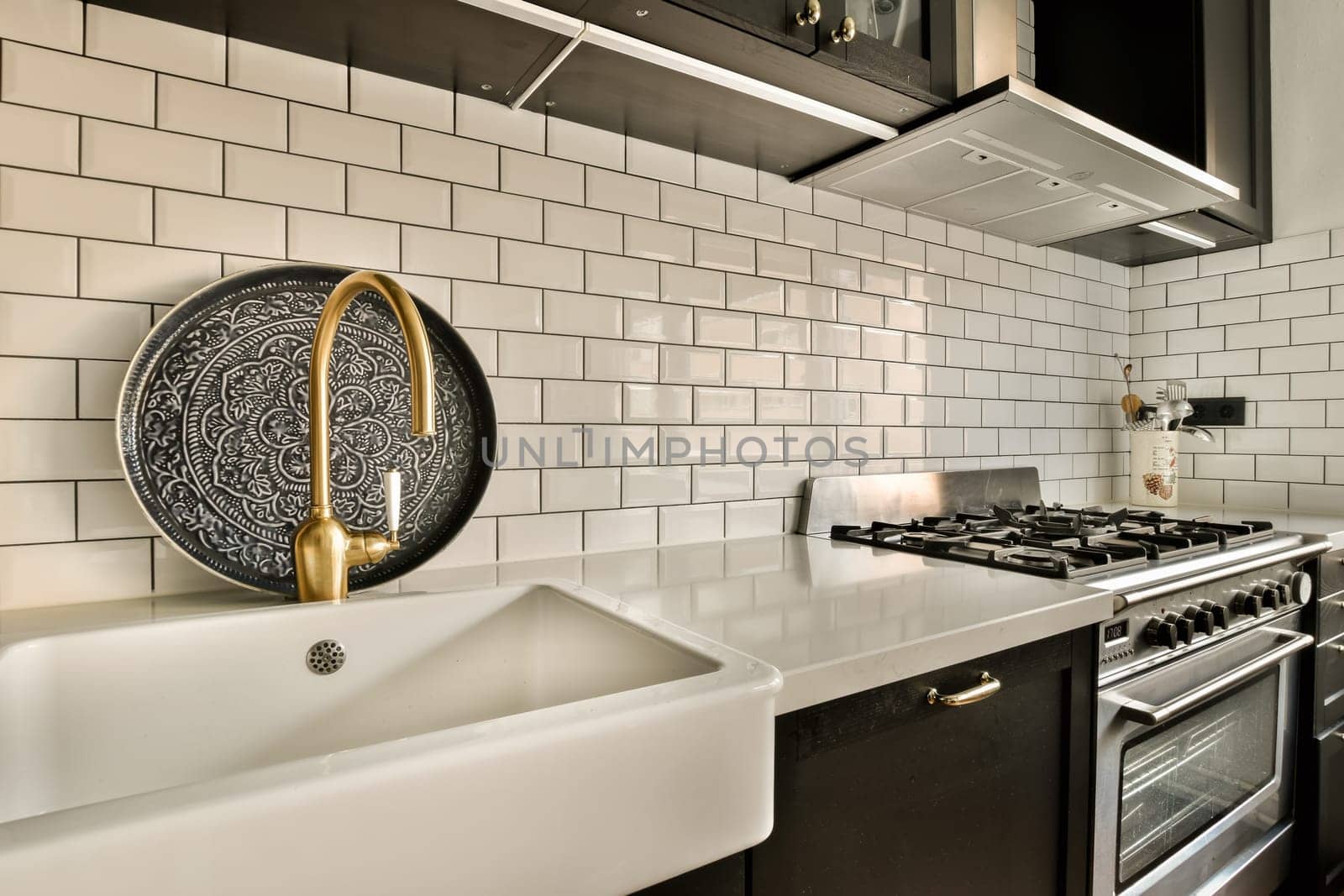 a kitchen with black and white tiles on the wall behind it is an oven, dishwasher and sink