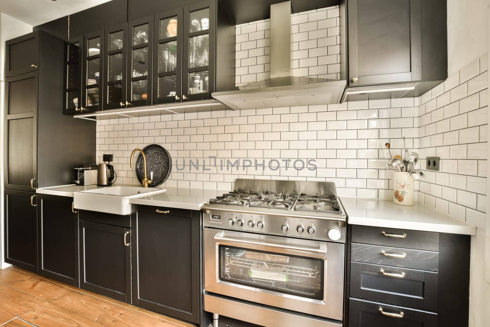 a kitchen with black cabinets and white subway tiles on the wall behind it is an oven, dishwasher and microwave