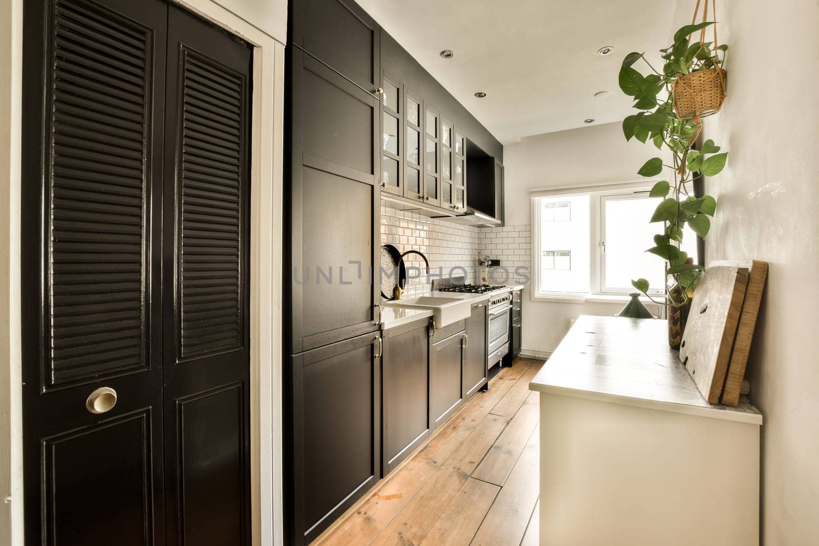 a kitchen with black cabinets and a white counter top by casamedia