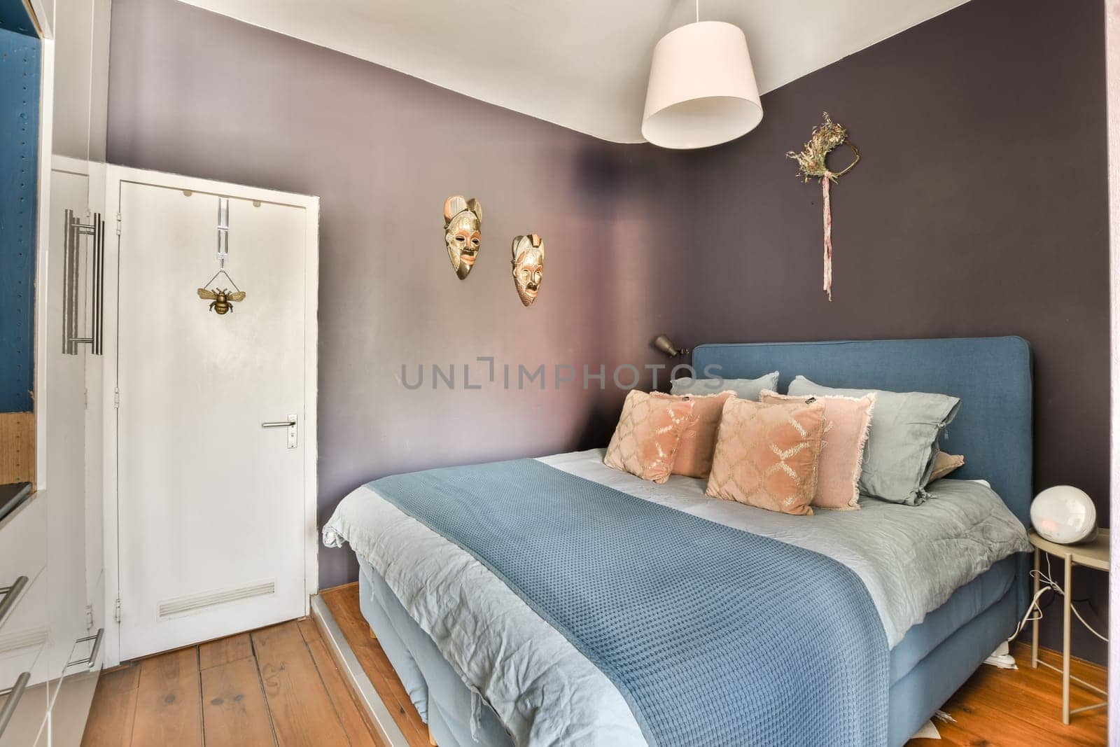 a bedroom with a blue bed and a purple wall by casamedia