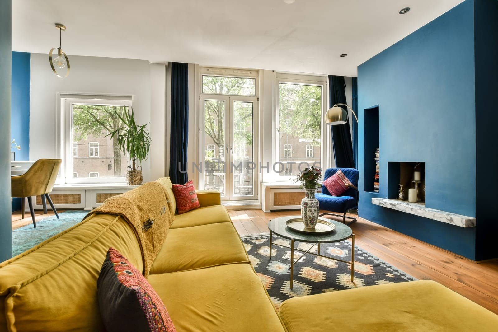 a living room with blue walls and a yellow couch by casamedia