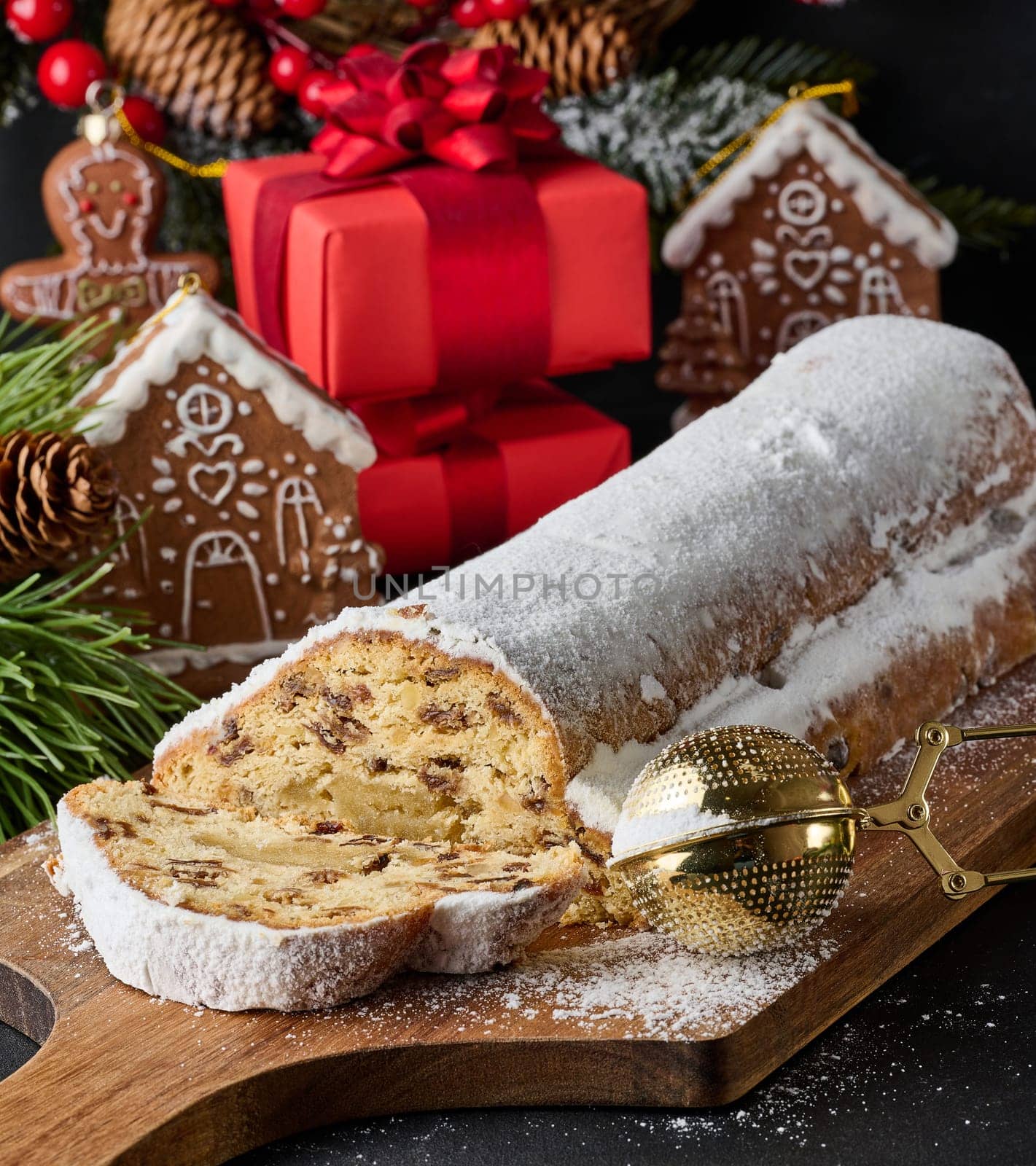 Christmas pastries stollen sprinkled with powdered sugar on the table, festive dessert by ndanko