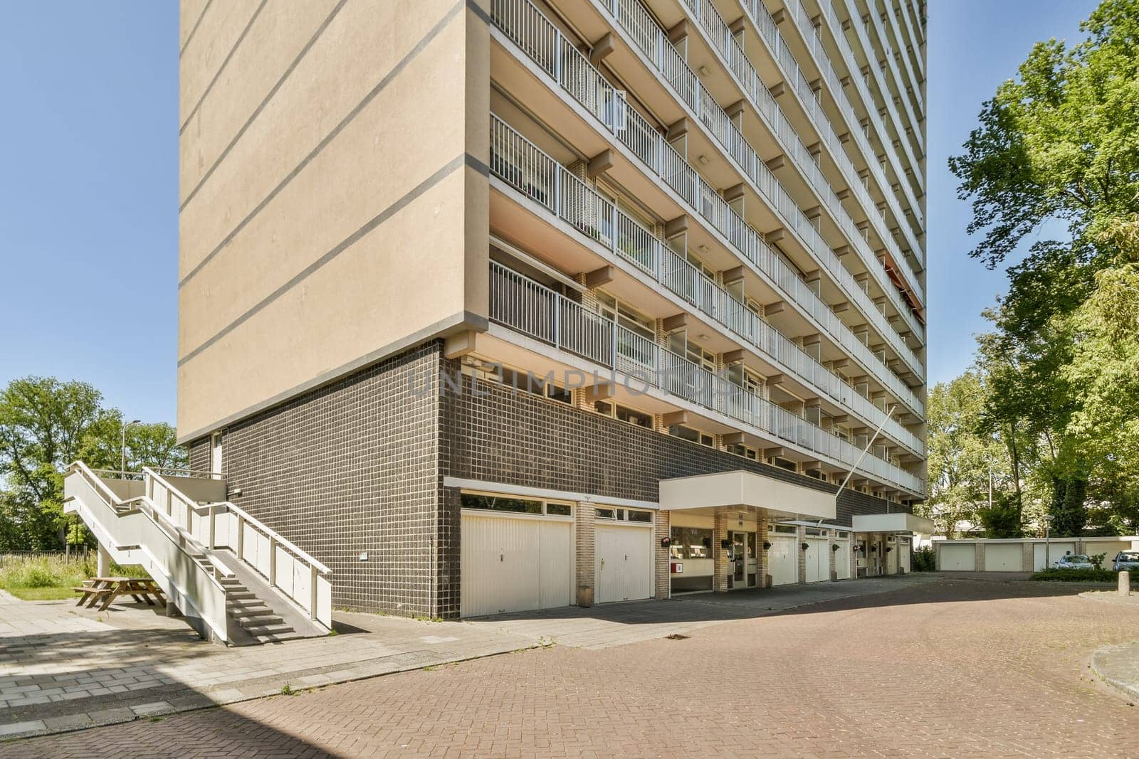 the outside of an apartment building with stairs leading up to the top floor and balknots on the second floor