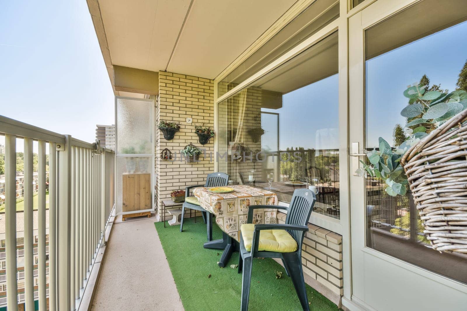 a patio with chairs and table on the left side, looking out onto the street in front of the house