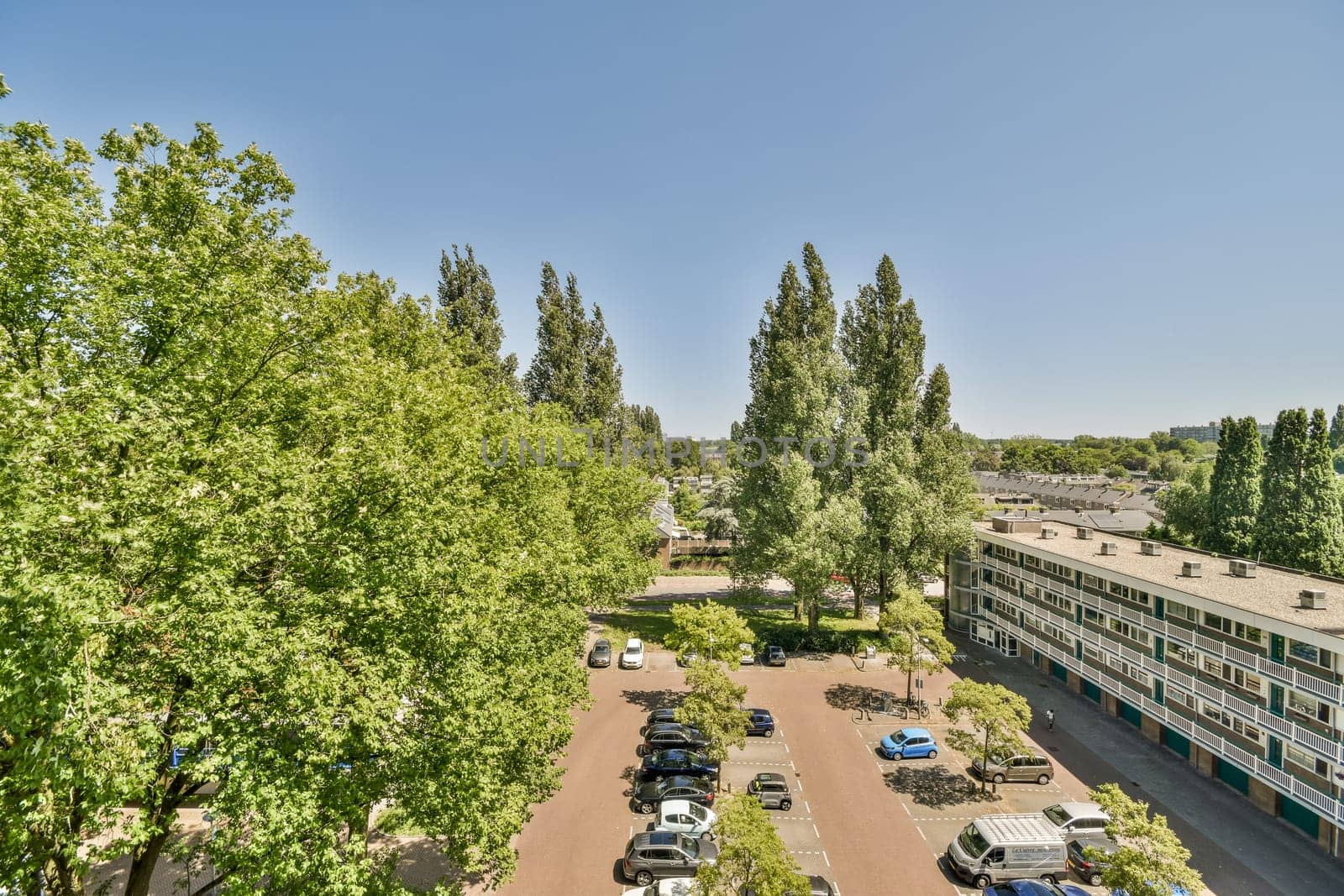 a view of a parking lot with trees and buildings by casamedia