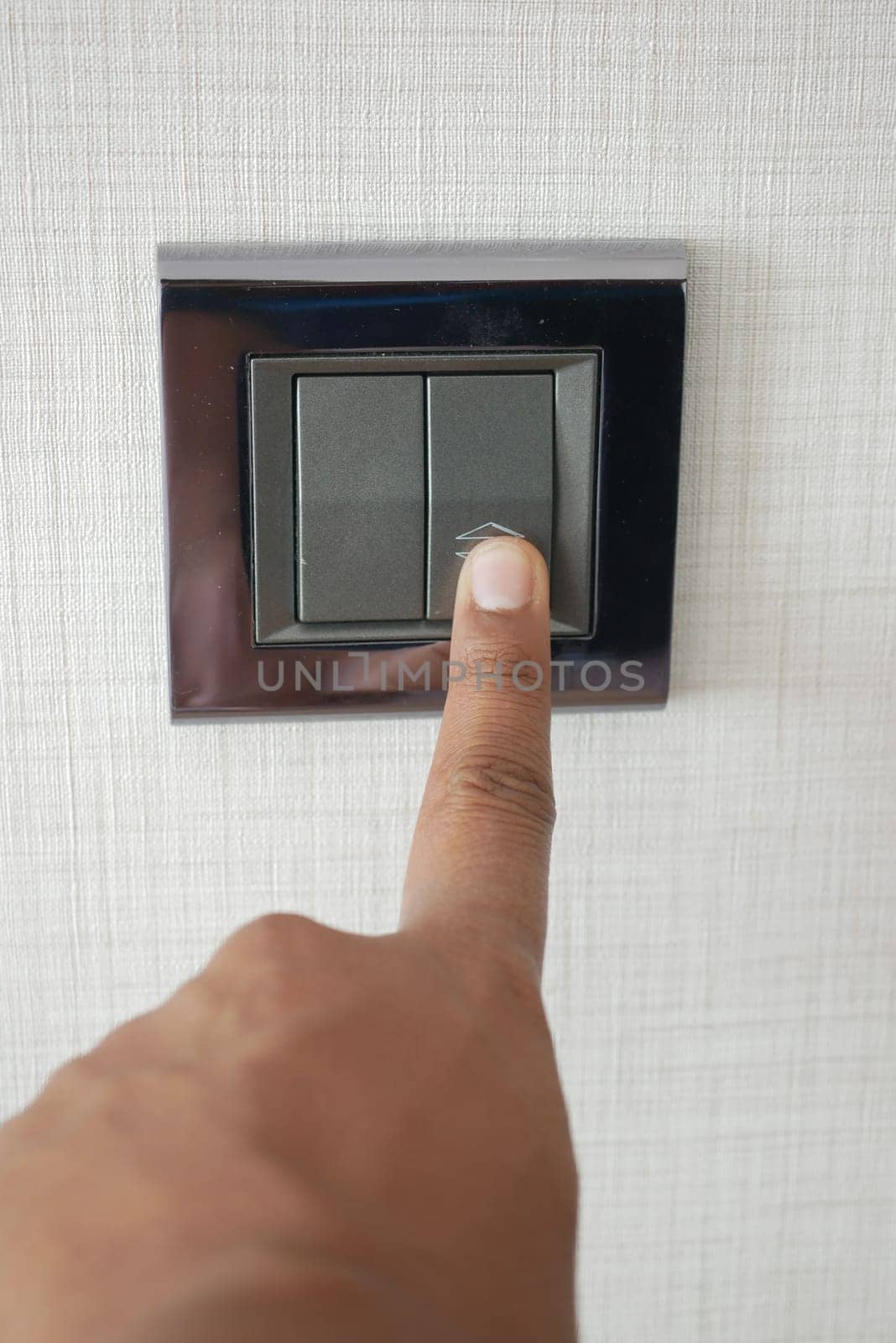 A finger turning on lighting switch