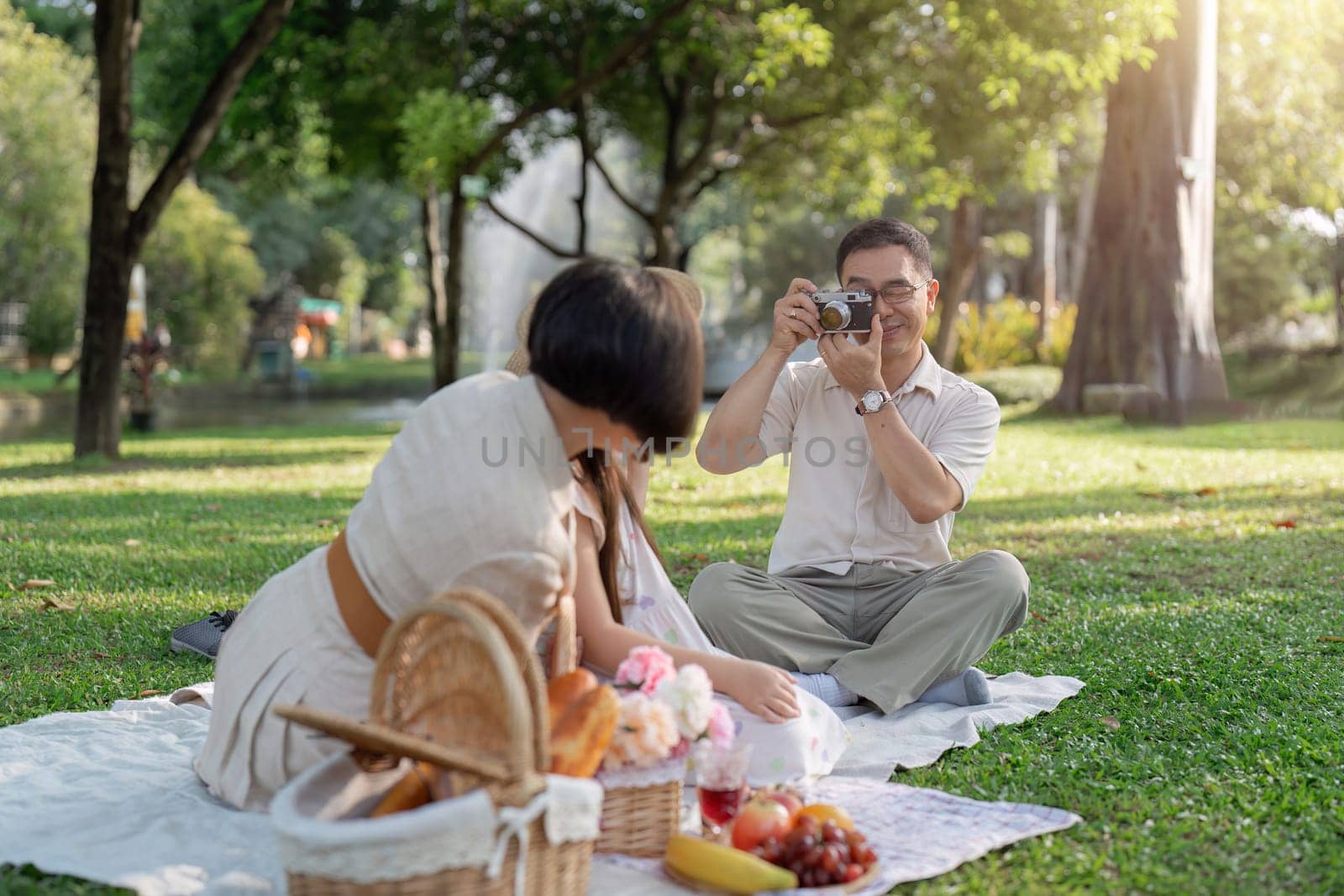 happy smiling family grandparent and grandchild picnic together outside at park.