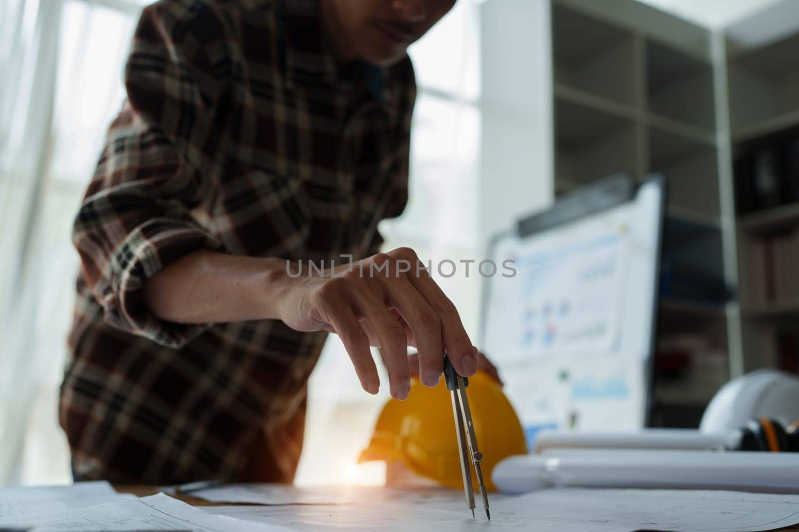 multi ethnic engineer brainstorming and measuring for cost estimating on blueprint and floor plan drawings about design architectural and engineering for houses and buildings.