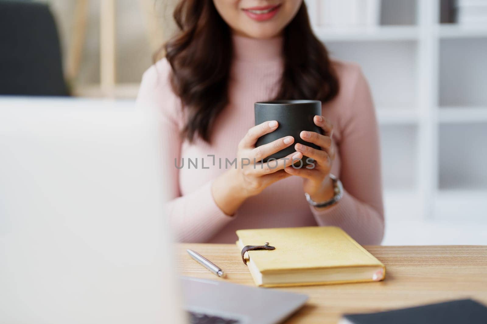 Woman relaxing wearing headphones and drinking coffee at home. by Manastrong